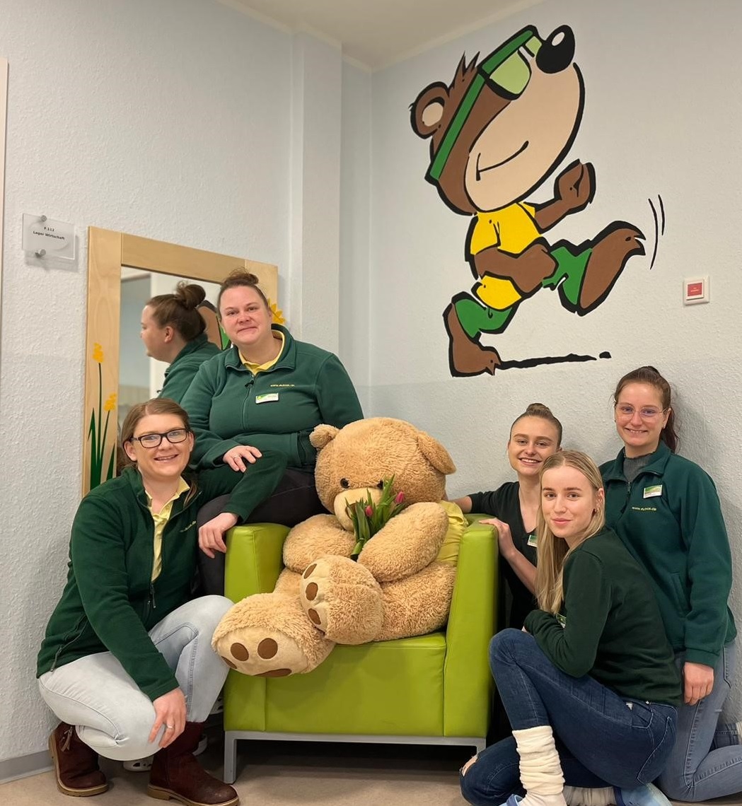Fünf EUBIOS-Mitarbeiterinnen gemeinsam mit einem großen Teddybären in der Klinik